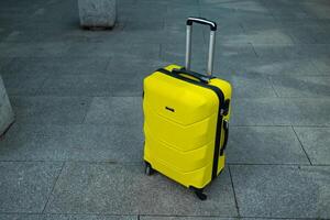 Stylish suitcase standing in empty airport hall, unrecognizable traveller's luggage waiting in terminal. photo