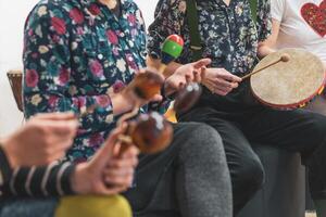Group of people playing on different kinds of musical instruments during music therapy photo