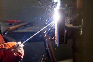Detail to welding process of metal parts, using a welding machine, bright sparks and flashes, industrial concept photo