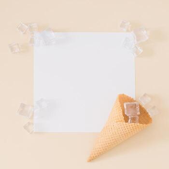 Creative trendy layout made with ice cream cone, ice cubes and paper card note copy space on light beige background. Minimal summer concept. Flat lay. photo