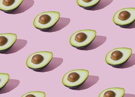 Trendy fruit pattern made of avocado on light pastel pink background. Minimal layout. Nature summer concept. photo