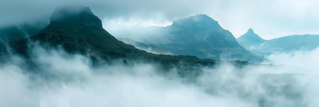 Early morning mist envelops rugged mountains creating a mystical scene. photo