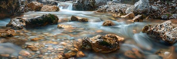 Crystal clear mountain stream flows smoothly over large boulders. photo