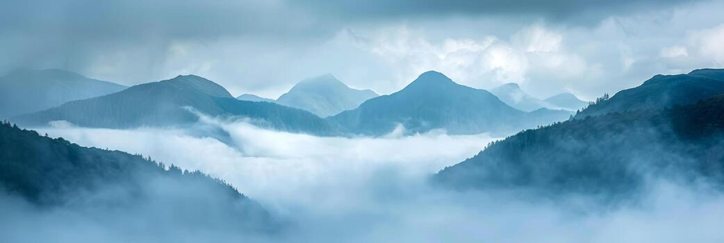Soft fog drifts through mountain valleys under a cloudy sky. photo