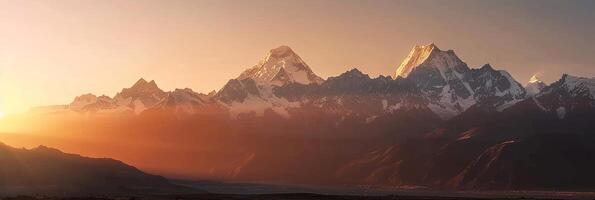 Last light of day casts a soft glow on snow-capped mountains. photo