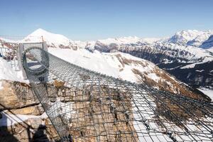 Experience stunning views at Murren ski resort, Switzerland. Walk out on a secure metal walkway with a mesh floor to witness majestic Swiss Alps scenery. photo