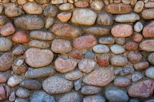 wall made of many colorful round stones, full-frame background and texture photo