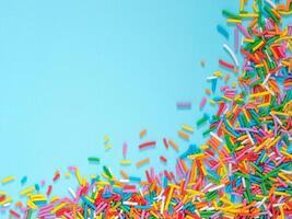 Border frame of colorful sprinkles on blue background photo