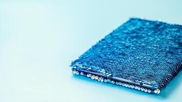 Sequin notebook on blue background, copy space photo