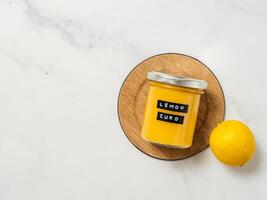 Homemade lemon curd in jar, top view, vertical photo