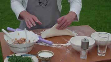 cook rolls out the dough with a rolling pin, turns the dough over on a table with flour video