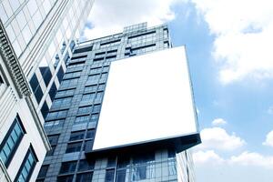 Mock up white vertical large LED display billboard on tower building with blue sky background .clipping path for mockup photo