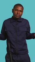 Vertical Clueless security guard shrugging shoulders, unable to answer people inquiries. Portrait of bodyguard doing lacking knowledge hand gesture, isolated over studio background, camera B video