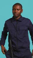 Vertical Portrait of security agent securing assigned post, turning on flashlight, studio background. African american guardian prepared to handle security breaches, using lantern device, camera B video