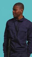 Vertical Portrait of security guard looking around while overseeing premises. Private law enforcement worker doing surveillance job, inspecting location, studio backdrop, camera B video