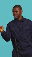 Vertical Portrait of security guard pointing finger at intruders while overseeing premises. Private law enforcement worker scolding unwanted trespassers, studio backdrop, camera B video