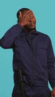 Vertical Portrait of tired security guard suffering from painful headache while overseeing premises. Private law enforcement worker feeling ache from fatigue, studio backdrop, camera B video
