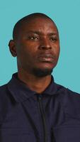 Vertical Headshot portrait of security guard at work smiling and overseeing premises. Joyful private law enforcement worker grinning while doing job, close up shot, studio backdrop, camera B video