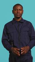 Vertical Security guard doing pretending to shoot gun hand gesture while being tasked with preventing criminal activity. Portrait of bodyguard doing pistol fingers gesturing, studio background, camera B video