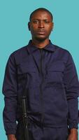 Vertical Security guard in threatening pose, tasked with preventing criminal activity and detaining suspects performing crimes. Portrait of menacing bodyguard crossing arms, studio background, camera B video