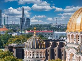 The Nativity of Christ Cathedral in Riga, Latvia. Byzantine-styled Orthodox cathedral, the largest in the Baltic region, with golden colored dome, polished gilded cupolas gleaming through the trees photo