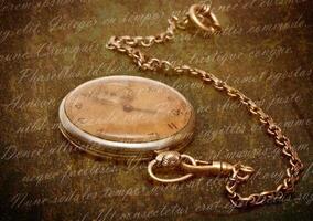 Old clock with chain lying on rough green surface photo