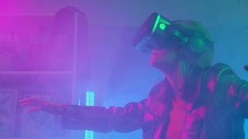 Young woman using virtual reality goggles in the dark room with neon lighting 4K slow motion RED camera. Wireless technologies. video