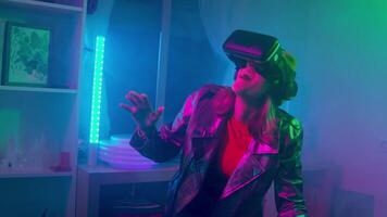 Young woman using virtual reality goggles in the dark room with neon lighting 4K slow motion RED camera. Wireless technologies. video