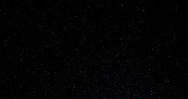 Cinematic dust particles floating on black background in slow motion. Atmosphere overlay. Filmed with RED camera video