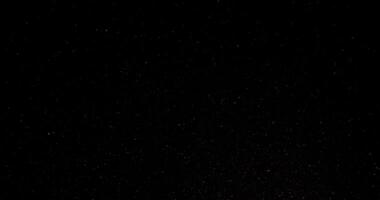 Cinematic dust particles floating on black background in slow motion. Atmosphere overlay. Filmed with RED camera video
