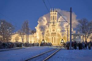 Russia, Peterhof, 07 January 2024. Two Santa Claus Trains leave the magically decorated building of the New Peterhof station, huge steam clubs, many people, incredible lighting photo
