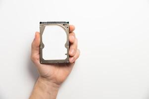 Man's hands showing a hard drive from a desktop computer close-up on a white background photo