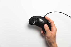 Black retro joystick on a white background in a man's hand. View from above photo