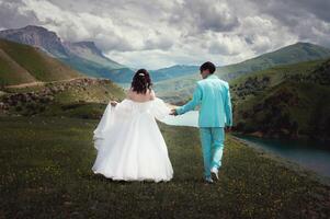 Wedding couple walking against the backdrop of beautiful scenery. Mountains covered with clouds photo