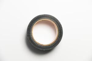 A roll of black reinforced adhesive tape, for sealing joints of roofing materials, when installing the roof, lying down, on a white background photo
