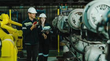 Teamwork of engineers man and woman inspecting the Check quality of compact desktop robotic armEngineer work at robotic arm factory. Technology and engineering concept. photo