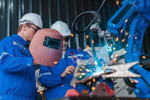 Teamwork of male engineers checking and maintaining the quality of the robot arm, robot arm factory Technology and engineering concepts. photo