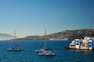 Sunset in Mykonos, Greece, with cruise ship and yachts in the harbor photo