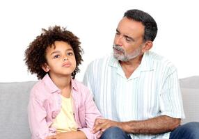 Kid Mental Problem. Supportive Grandpa Talking To Depressed Naughty Little Grandson While Boy Sulking Sitting On Sofa At Home. Multigenerational Communication Issues Concept photo