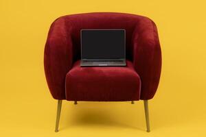 Laptop Computer With Empty Screen, Mockup For Online Website Advertisement, Standing On Red Armchair Over Yellow Background, Studio Shot Of Portable PC. Freelance And Internet Technology photo