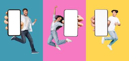 Positive excited young guys and woman jumping from joy and show phone with empty screen, isolated on colored background, collage. Great advice, offer and digital ad, new app, panorama photo