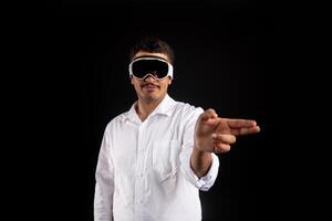 Businessman wearing new vision pro VR glasses, touching virtual screen or objects by fingers, interacting with cyberspace. Modern man in virtual reality goggles playing online game photo