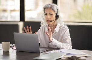 Virtual Assistance. Business Lady With Headset Solving Customer's Issues Calling Via Laptop, Talking Online In Office. Hotline Operator Career, Communication And Client Support Service photo