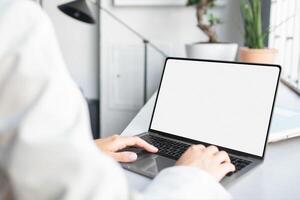 Unrecognizable businesswoman using laptop computer with white blank screen, typing on keyboard, mockup for ad, website design, copy space photo