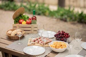 Set Of Summer BBQ Or Picnic Food On Served Wooden Table With Glasses And Plates Outdoors, Selection Of Ungrilled Meat On Skewers, Fruits, Fresh Vegetables And White Wine, Barbecue Leisure Concept photo