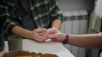And two middle-aged men hold hands during their difficult communication And their relationship in the kitchen in a modern apartment. Relationships and mutual understanding during a difficult video
