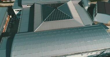 A modern building with a glass roof from a bird's eye view, highlighting its innovative design, impressive architecture, and urban landscape video