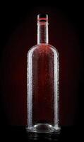 Empty wet glass bottle on a beautiful illuminated background. photo