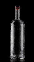 Empty wet glass bottle on a dark background. photo
