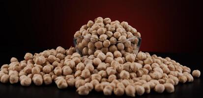 Glass cup with chickpeas on a beautiful illuminated red background. photo